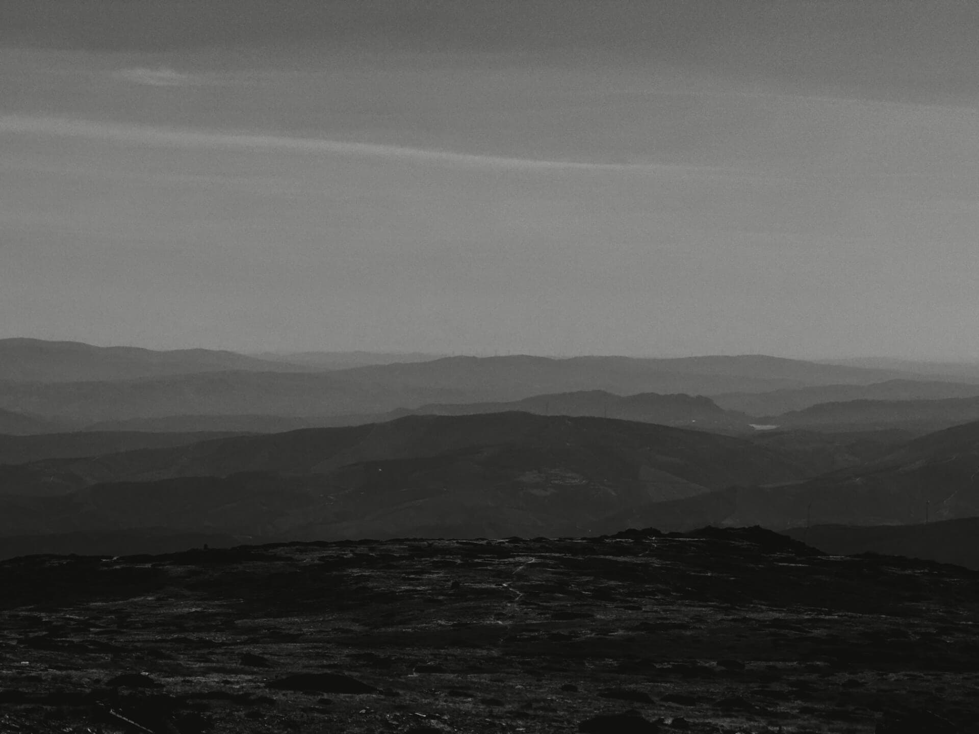 Layered mountain ridges fading into the distance at sunset in black and white