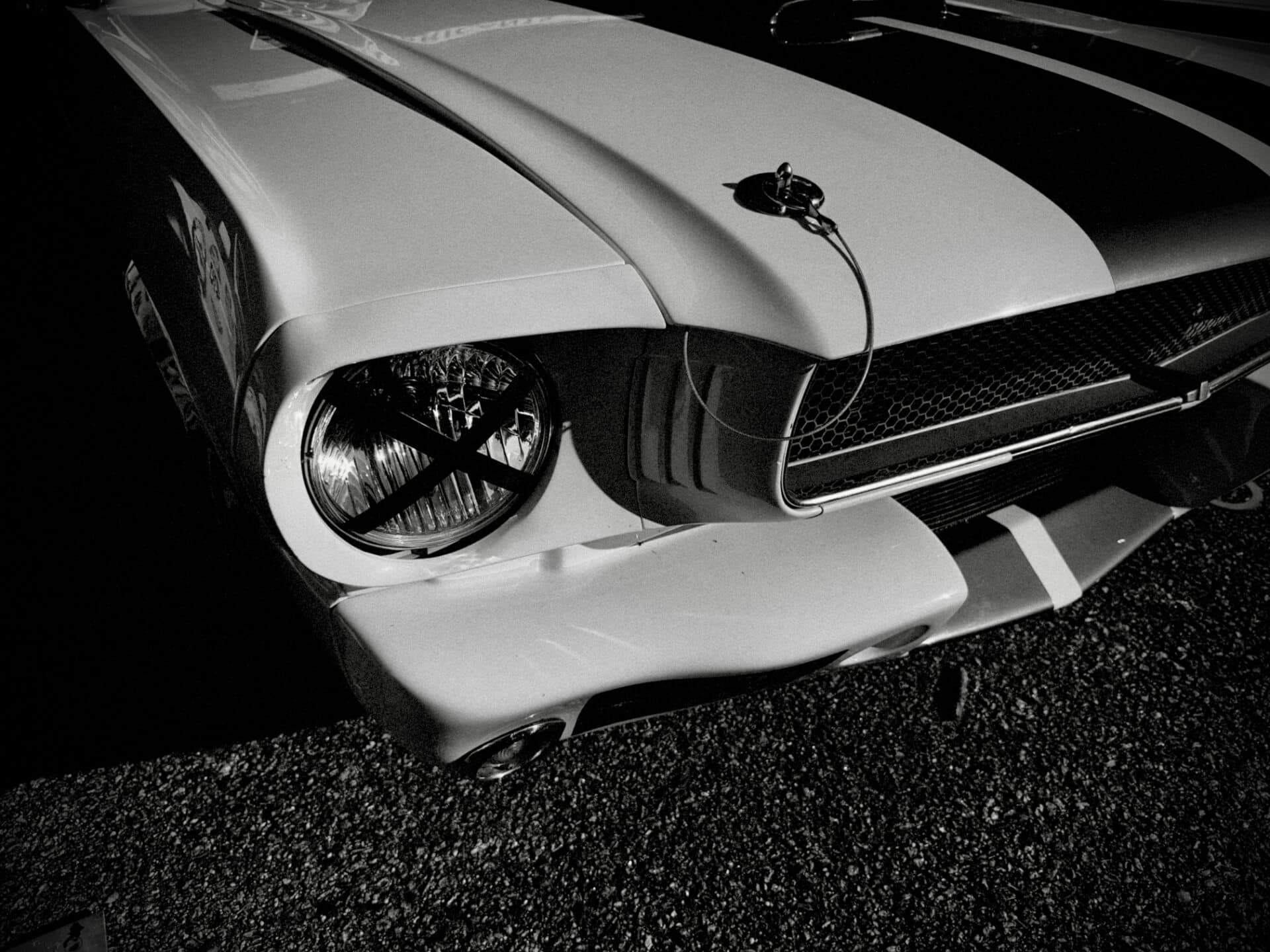 Classic Shelby Mustang front fender and headlight detail in black and white