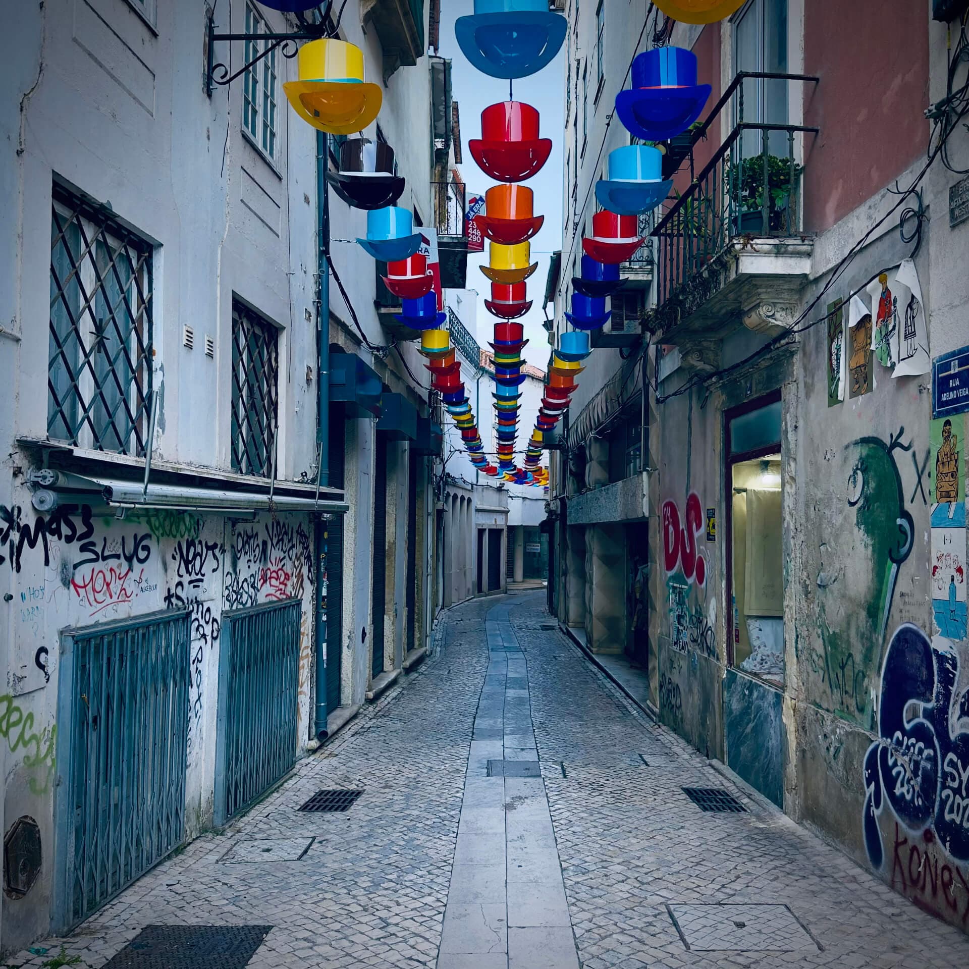 Narrow Lisbon alley decorated with colorful hanging flower pots