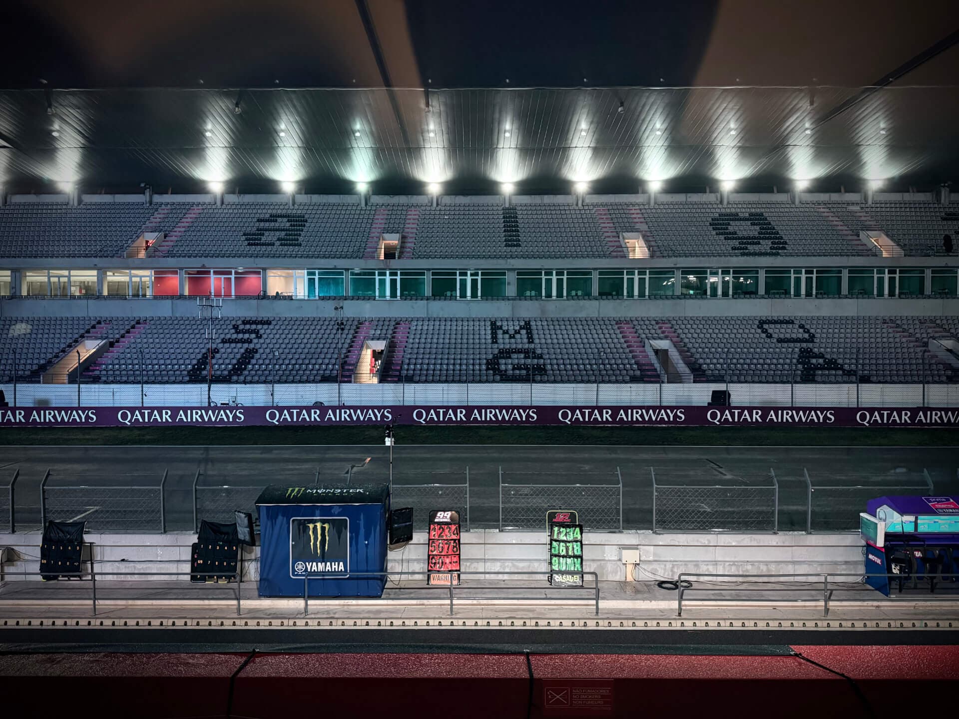 Empty MotoGP grandstand illuminated at night at Algarve International Circuit